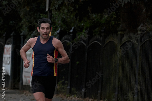 Runner. A man in sports outfit runs along the street. © Angel Santana