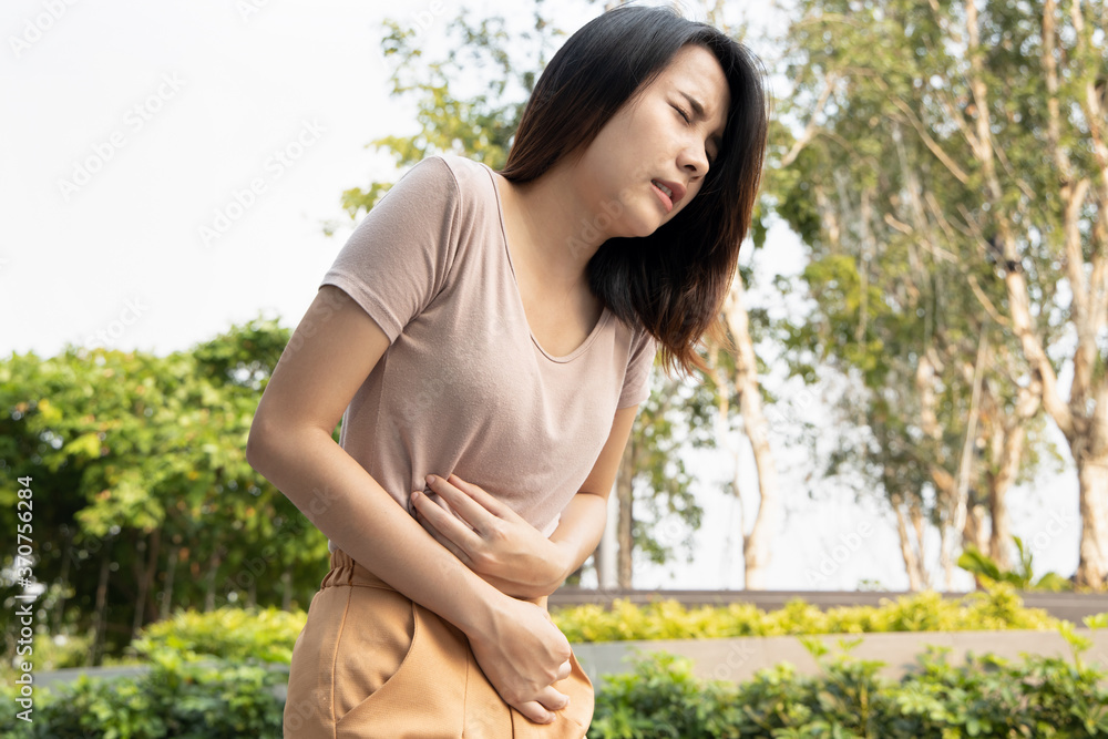 woman with stomach ache; sick asian woman suffering from stomachache, menstrual period cramp, abdominal pain, food poisoning, gastritis, acid reflux; asian young adult woman health care model woman with stomach ache; sick asian woman suffering from stomachache, menstrual period cramp, abdominal pain, food poisoning, gastritis, acid reflux; asian young adult woman health care model