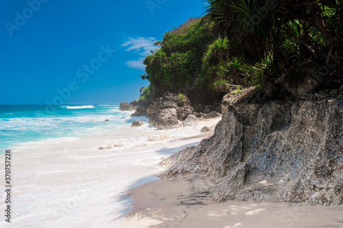 Tropical wild beach with white sand and turquoise sea with waves