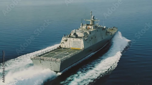 Side drone shot of a cruising navy ship
