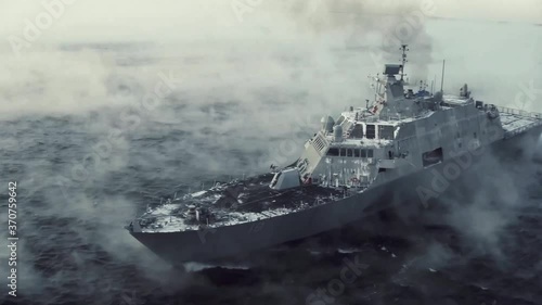 Flyby drone shot of navy ship on foggy sea photo