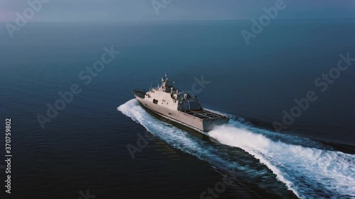 Wide drone shot of cruising navy ship photo