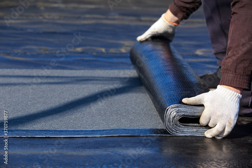 Obraz na płótnie Worker puts roofing material