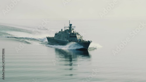 Drone shot of cruising navy ship, front