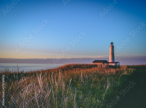 lighthouse At Sunset. Forillon National Park, Canada photo