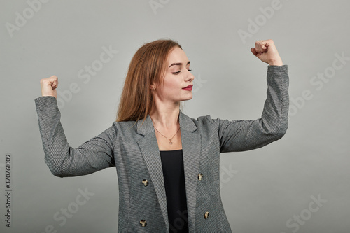 Feels proud have strength, shows great power, raises arms to show muscles confident in victory, looks strong and independent, flexing arm, facial expressions, feelings, attitude, life perception