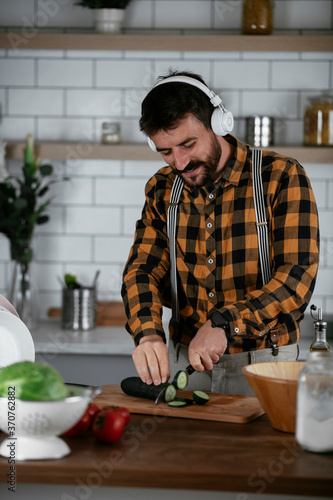 Portrait of handsome man in kitchen. Young man preparing delicious food.