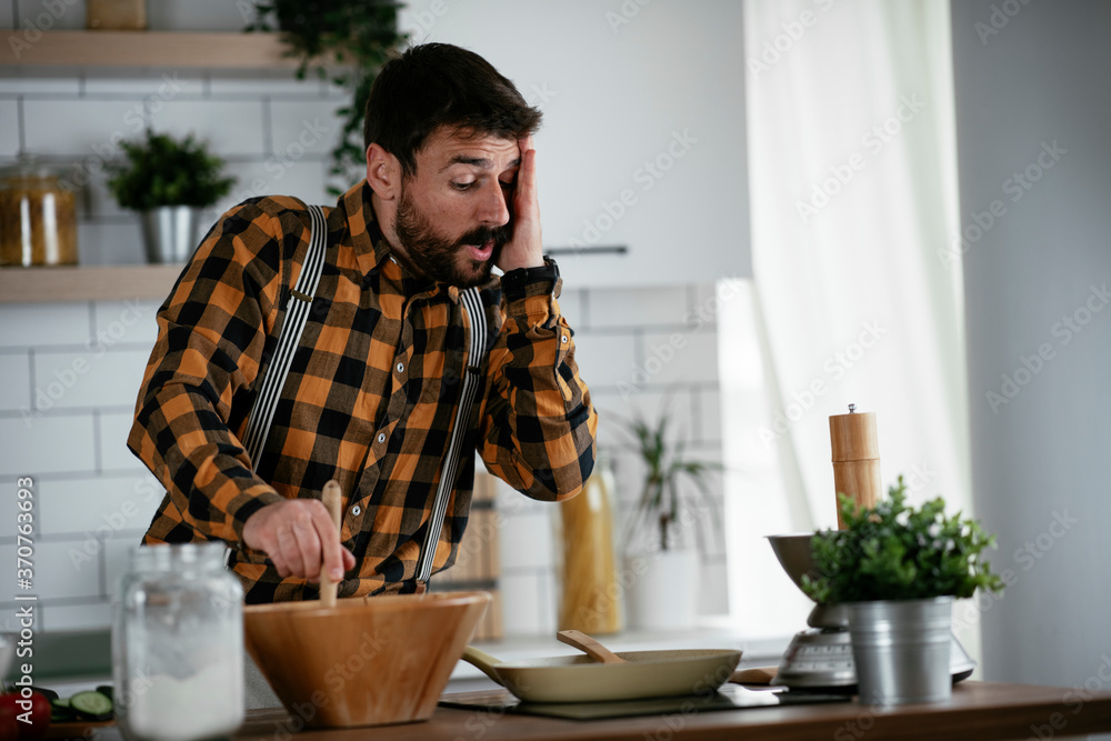 Portrait of handsome man in kitchen. Young man preparing delicious food. Portrait of handsome man in kitchen. Young man preparing delicious food.