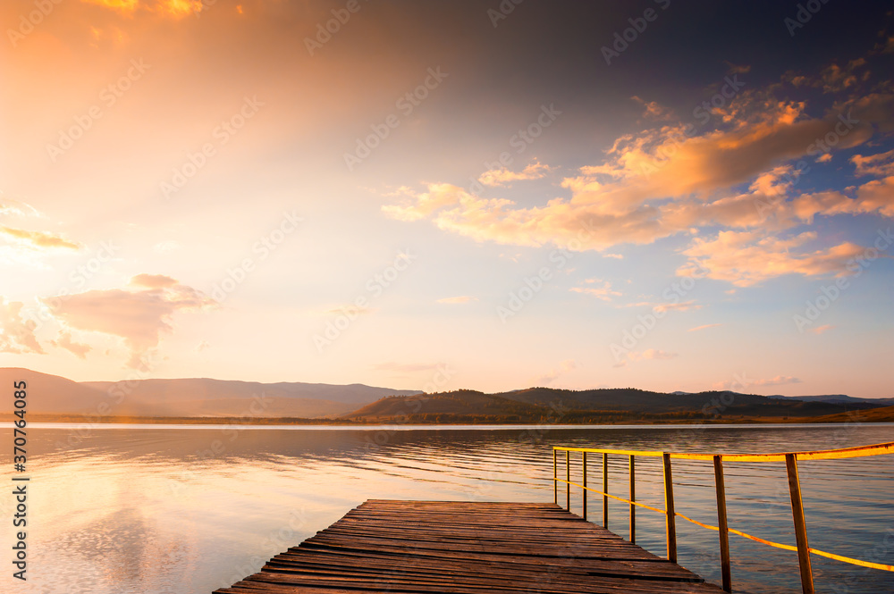 Old wooden pier on the lake at sunset. Beautiful autumn landscape. South Ural, Bashkortostan, Russia