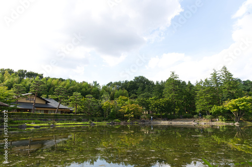 HDR natural Japanese style decoration park and garden decorated greenery tree, Japanese style house and bush with its mirror reflection on clear water pond.