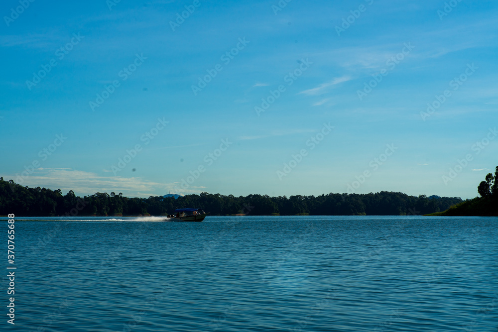 Kenyir, Malaysia - July 23, 2020: Speed boat moving fast. Kenyir, Malaysia - July 23, 2020: Speed boat moving fast.