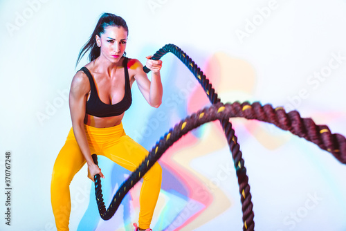 Fit woman training hardwith ropes photo