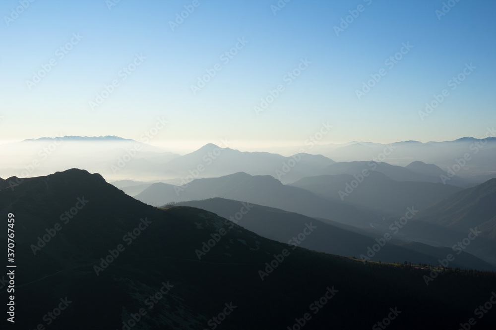Mala Fatra and Velka Fatra in the distance, Slovakia, Europe - silhouette of mountains and hills in the morning. Hazy and misty nature and landscape.