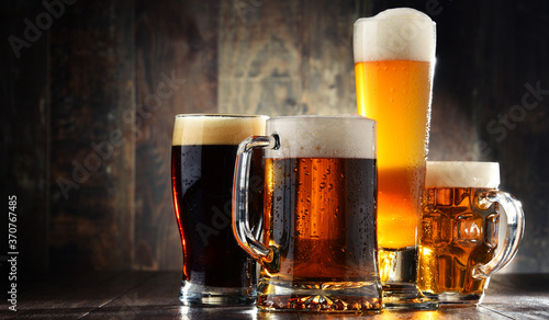 Four glasses of beer on wooden background