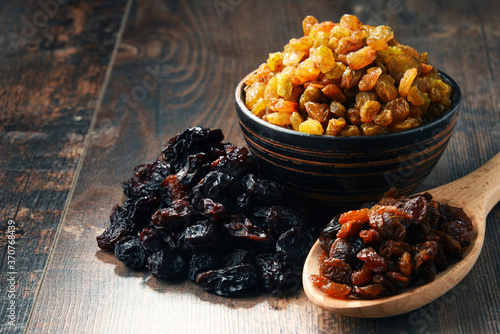 Composition with bowl of raisins on wooden table