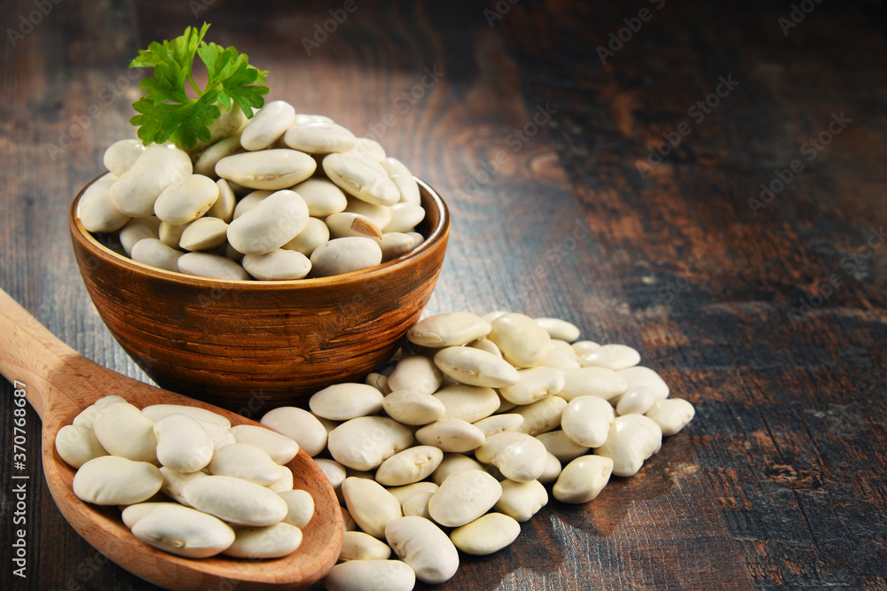 Composition with bowl of white beans on wooden table Composition with bowl of white beans on wooden table