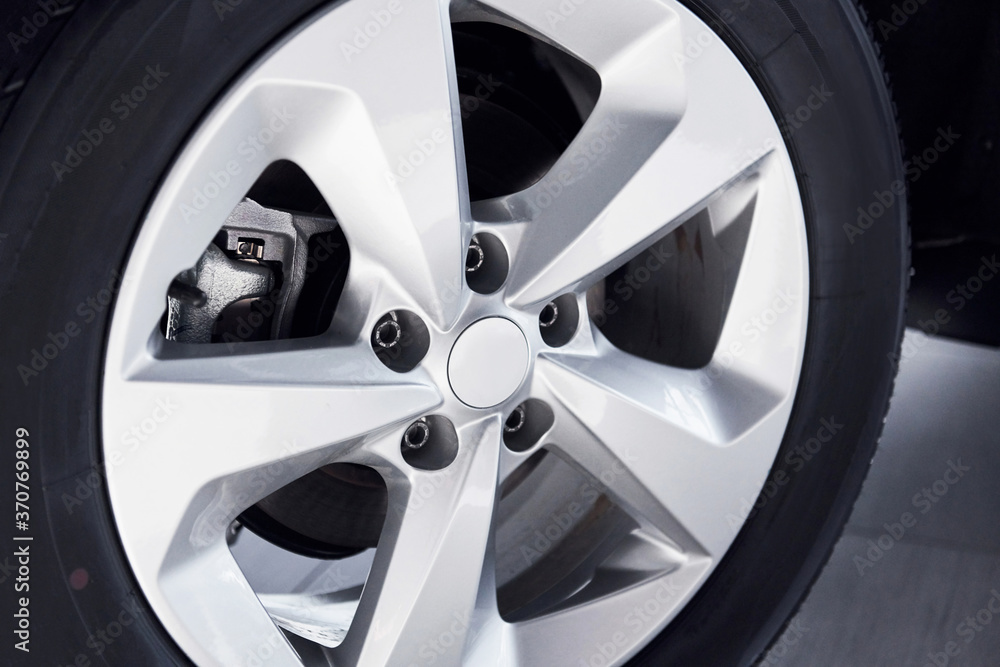 Close up view of automobile's wheel. Brand new car parked indoors