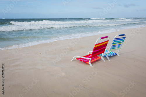 Two empty beach chairs facing the ocean