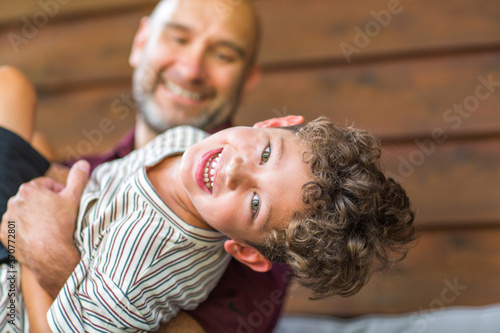 Hispanic father sitting and hugging his son.
