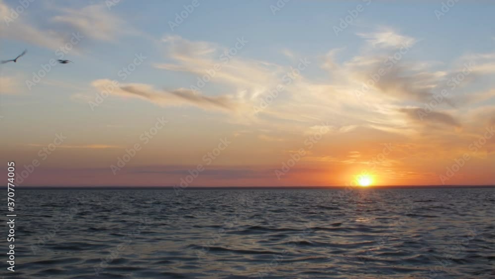 picturesque time lapse of sunset on sea,sun hiding behind horizon of water, clouds floating illuminated by sun rays in blue sky, summer nature background
picturesque time lapse of sunset on sea,sun hiding behind horizon of water, clouds floating illuminated by sun rays in blue sky, summer nature background