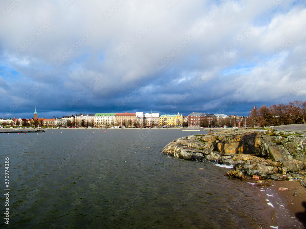 Panorama of Helsinki seen from an island with partly cloudy sky on the background.