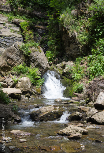 The mountain river flows down over the rocks