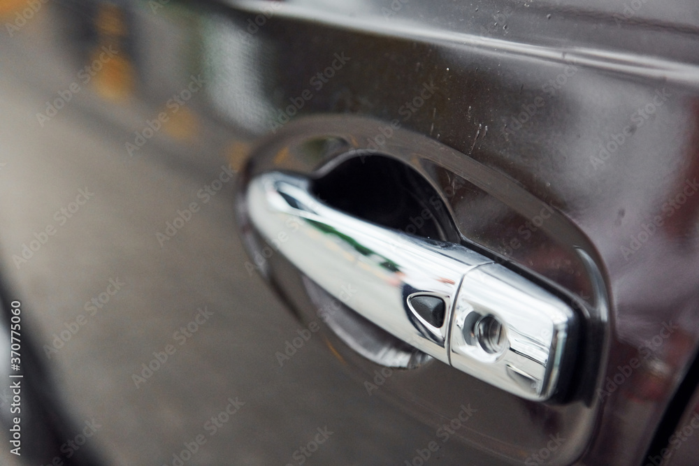 Close up view of silver colored automobile's door handle. Polished surface