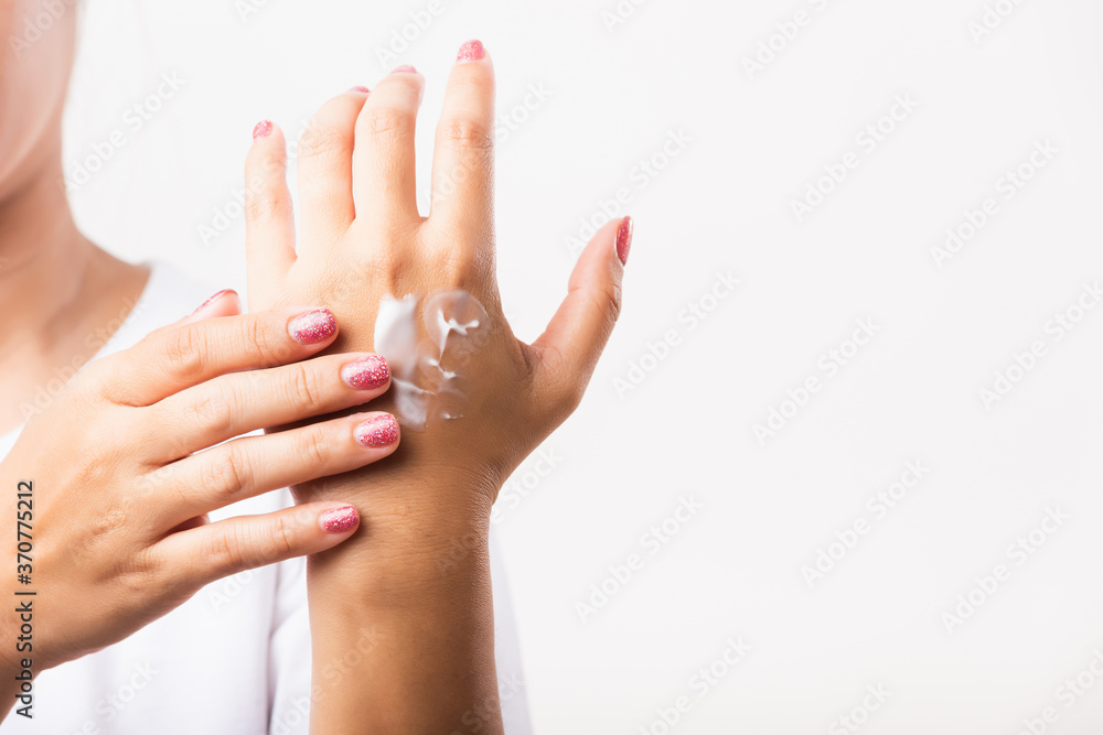 Closeup young Asian woman applying lotion cosmetic moisturizer cream on her behind the palm skin hand, studio shot isolated on white background, Healthcare medical and hygiene skin body care concept Closeup young Asian woman applying lotion cosmetic moisturizer cream on her behind the palm skin hand, studio shot isolated on white background, Healthcare medical and hygiene skin body care concept