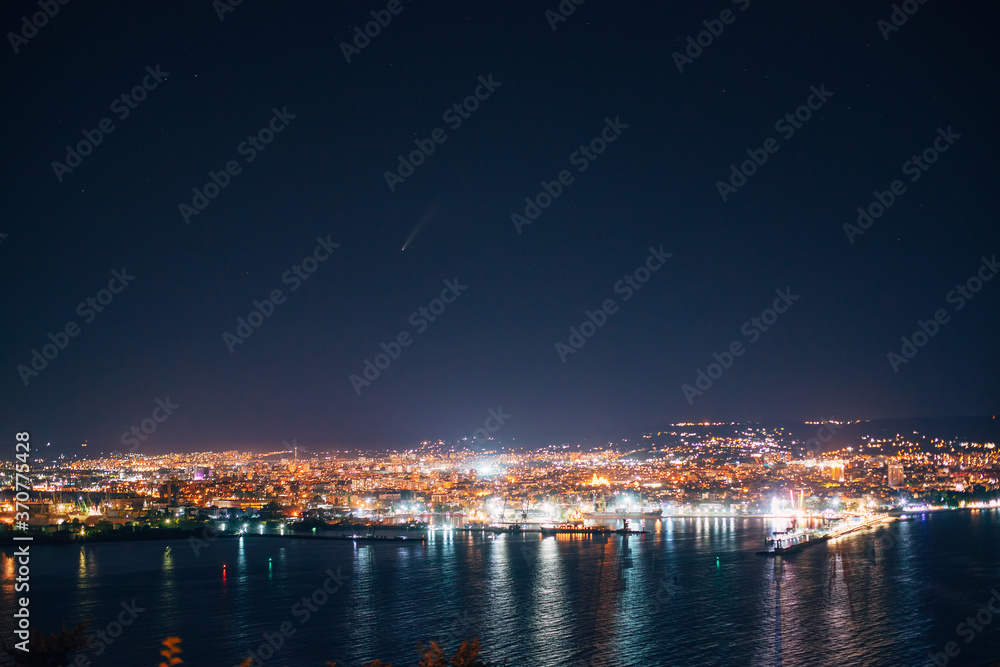 Night view toward Varna, Bulgaria. Seascape with reflection of city lights in the sea water.