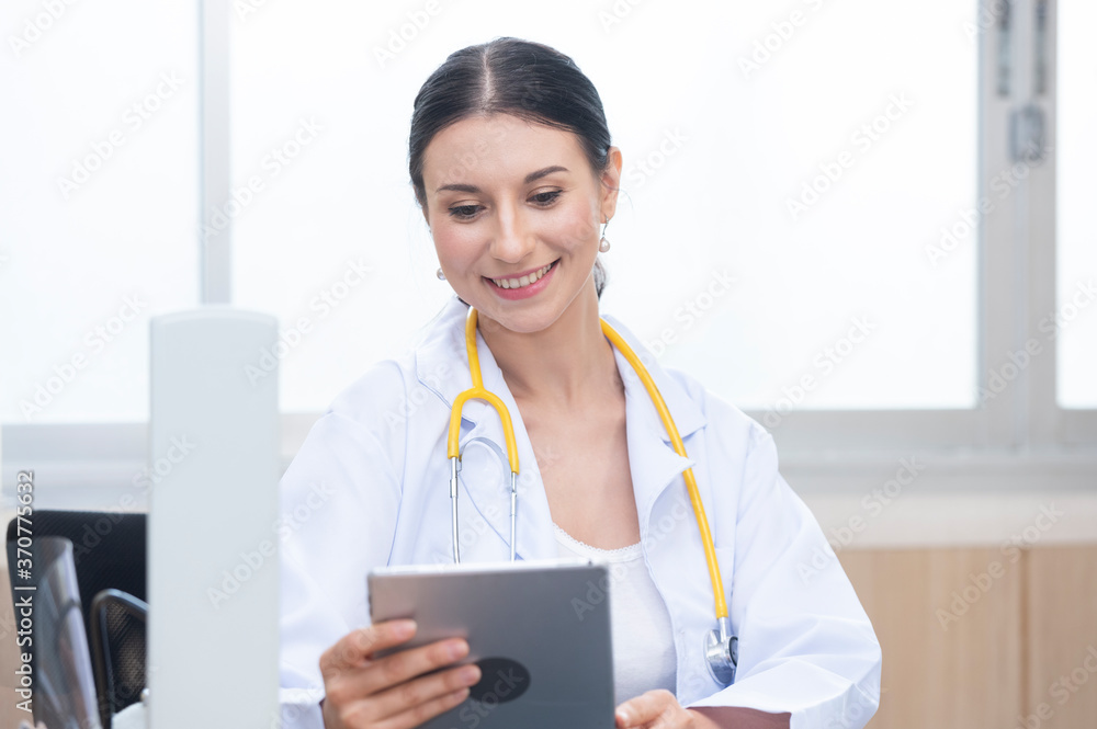 Female doctor sitting orthopedist use tablet in office hospital. Confident female doctor sitting at office desk, health care and prevention technology network concept Female doctor sitting orthopedist use tablet in office hospital. Confident female doctor sitting at office desk, health care and prevention technology network concept