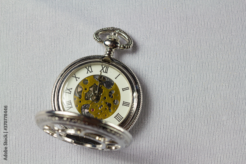 Old classical Pocket watch on white fabric background