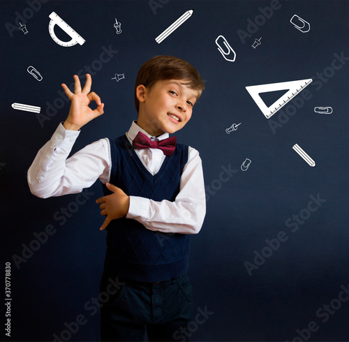 Back to school. Education. Happy schoolboy with a drawn school supplies: ruler, protractor, paper clips, buttons, pencil.
