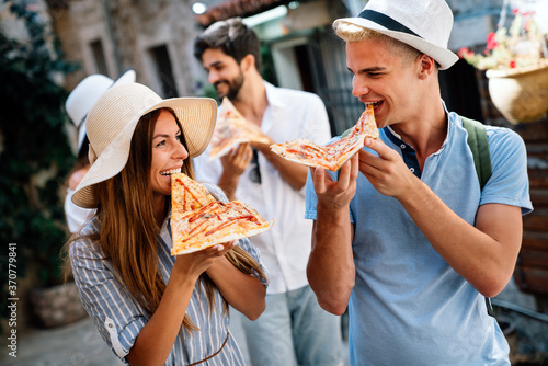 Group of friends having fun outdoor,eating pizza