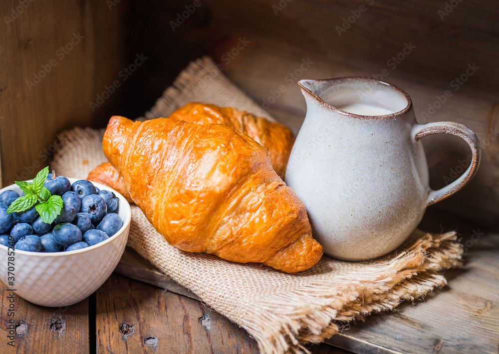 romantic breakfast with fresh croissants coffee,milk and berries on wooden table romantic breakfast with fresh croissants coffee,milk and berries on wooden table
