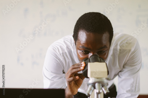 African scientist teacher looking microscopes in the laboratory