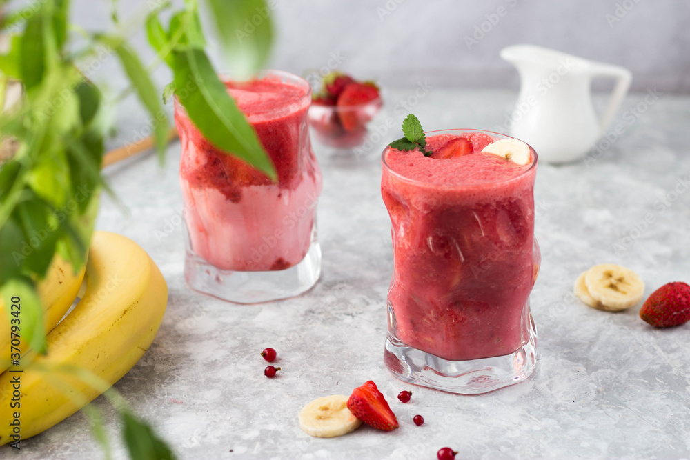 banana and strawberry cocktail in a glass with mint leaves in the sun banana and strawberry cocktail in a glass with mint leaves in the sun