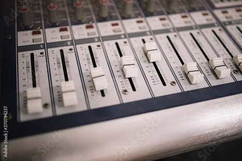 Selective focus image of DJ sound mixer. Close-up view of DJ channel mixing controller