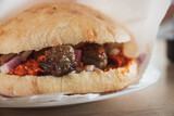 Closeup of Cevapi dish served on a plate. Traditional balkan cuisine, minced meat rolled into small sausages served in a bun with onions and ajvar sauce
