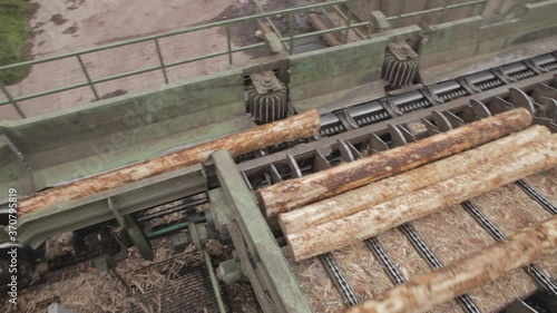 Pneumatic push plate moving timber logs onto a sorter in a saw mill photo