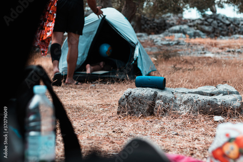 Bild auf Leinwand Wireless speaker standing on a rock outside, tents around it, camping in the nat