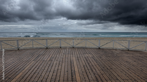 Paesaggio di mare con pavimento in legno e nuvole all'orizzonte. photo