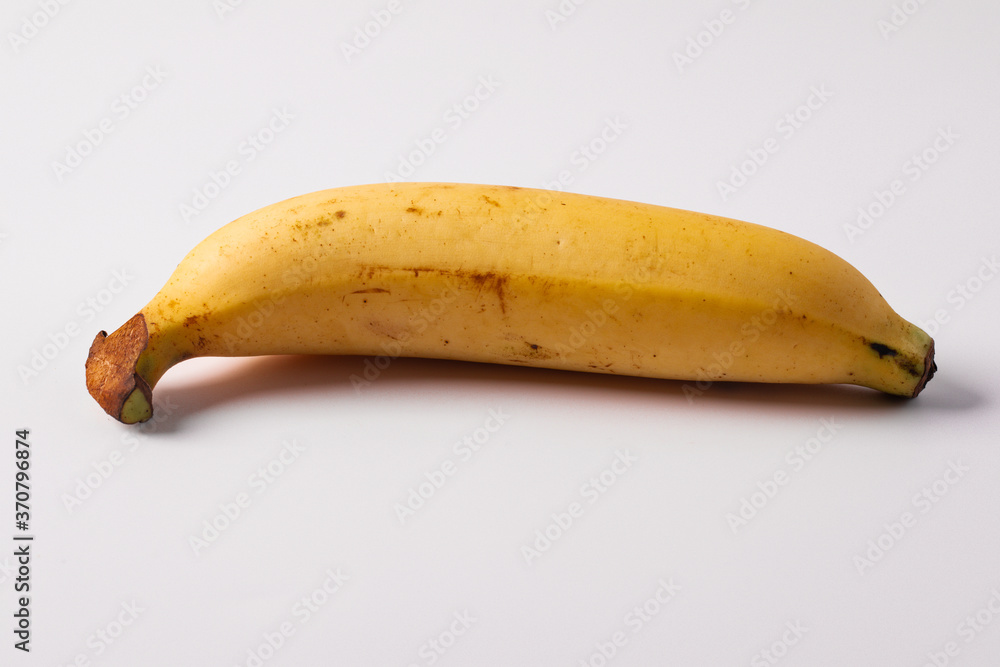 One banana on a white background. Copy space. One banana on a white background. Copy space.