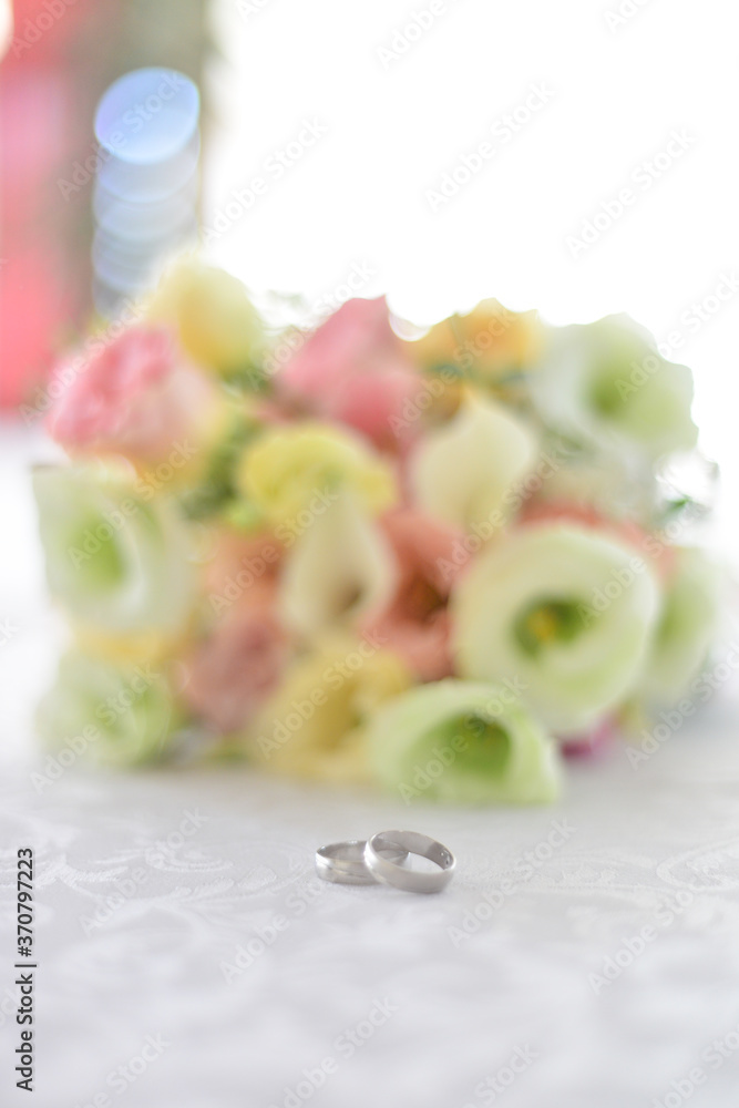 Rings on canvas with blurred roses in the background. Wedding concept. Rings on canvas with blurred roses in the background. Wedding concept.