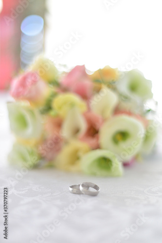 Rings on canvas with blurred roses in the background. Wedding concept.