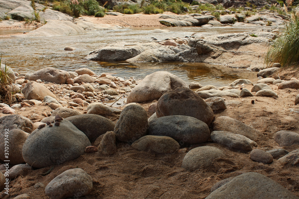 Tranquil landscape. View of the river flowing along the mountain forest.The sand, shore, rocks, and shallows. Tranquil landscape. View of the river flowing along the mountain forest.The sand, shore, rocks, and shallows.