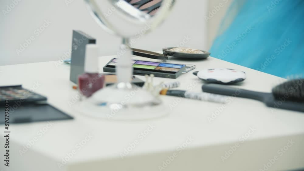Camera is moving along the table full of cosmetic supplies, then focuses on the cute kid that is doing make-up for her father. Camera is moving along the table full of cosmetic supplies, then focuses on the cute kid that is doing make-up for her father.