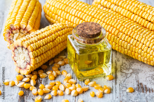 Corn essential oil bottle, corn groats, dry seeds and corncobs