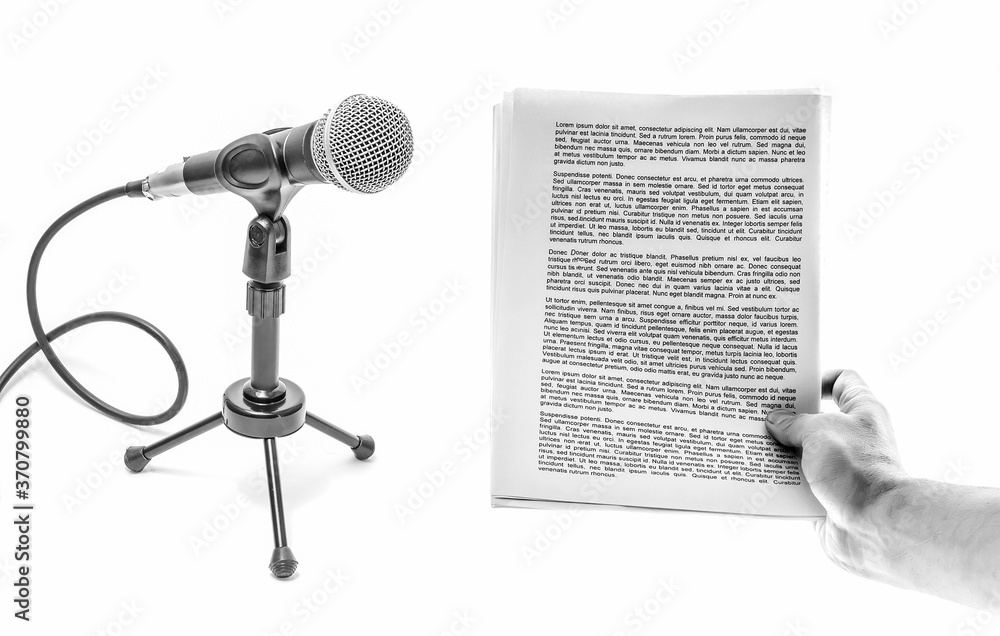 Fototapeta premium Hand holds a sheet of paper with text and microphone