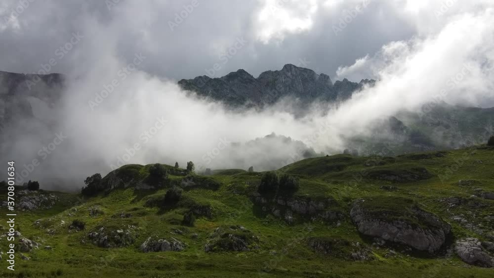 Flying over the mountains through the fog. The cloud is moving rapidly through the mountain valley. Timelapse. Aerial photography Flying over the mountains through the fog. The cloud is moving rapidly through the mountain valley. Timelapse. Aerial photography