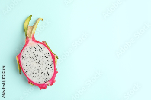 Half of delicious dragon fruit (pitahaya) on light blue background, top view. Space for text